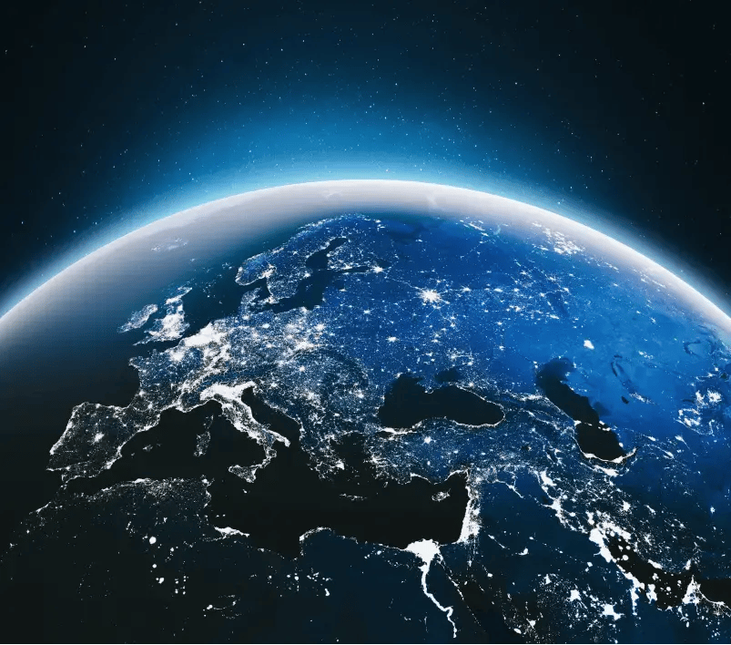 A satellite view of Europe at night. The bright lights show the distribution of population and major cities across the continent.